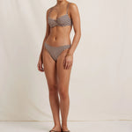 Woman wearing a checkered bikini set on a plain background