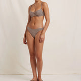 Woman wearing a checkered bikini set on a plain background