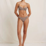 Woman wearing a checkered bikini against a plain background