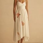 Woman wearing a white dress with floral details on a beige background
