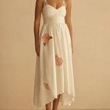 Woman wearing a white dress with floral details on a beige background