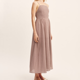women wearing maxi Dress features a square neckline, elasticated back and free-flowing maxi skirt. It turns to reveal a statement open back with an adjustable tie feature. Mocha Gingham